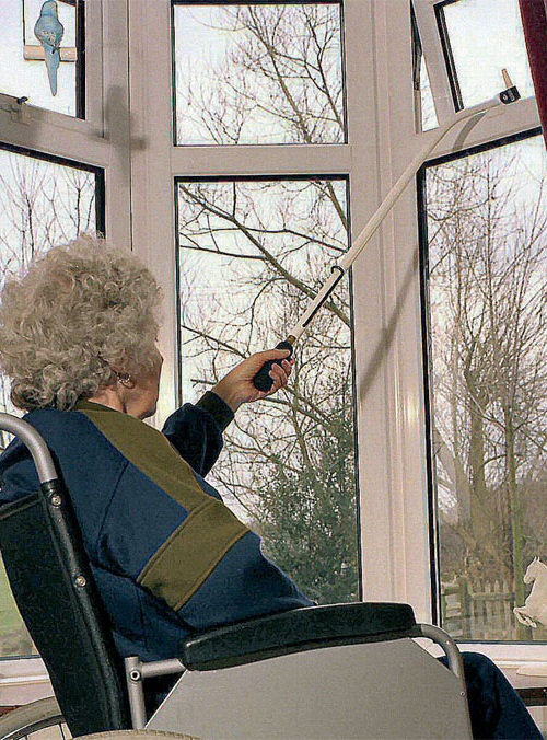 Lady in wheelchair using window pull